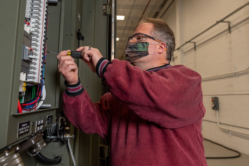 Photo of Electrician Ronald Semon works on a BDOC.