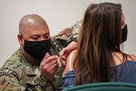 U.S. Air National Guard Tech. Sgt. Abraham Virata, a medical technician with the 146th Medical Group (146 MDG), administers a COVID-19 vaccination into the arm of a military dependent, at the Channel Islands Air National Guard Station, Port Hueneme, Calif., March 31, 2021.