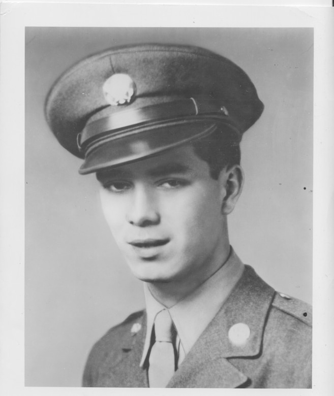 A young man wears a cap and dress uniform.