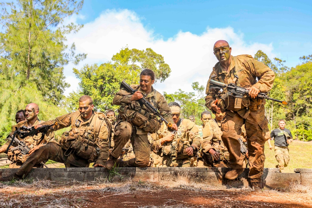 A group of soldiers move together while holding weapons.