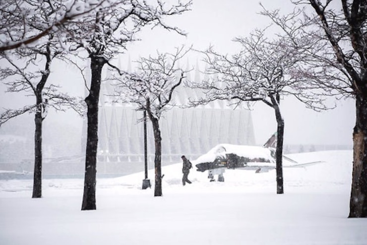 A cadet walks to classes through the snow.