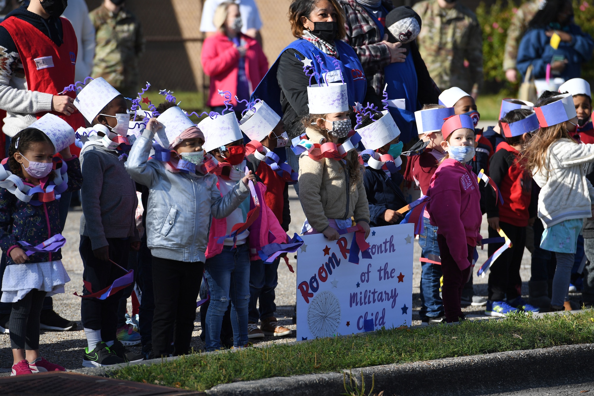 Children of Keesler personnel gather during a parade in front of the child development center at Keesler Air Force Base, Mississippi, April 1, 2021. The event was held in celebration of the Month of the Military Child, which is recognized throughout the month of April. (U.S. Air Force photo by Kemberly Groue)