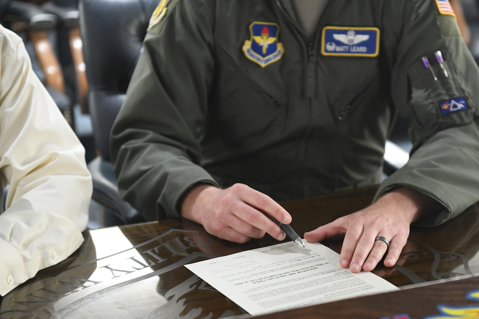 person signs document with pen