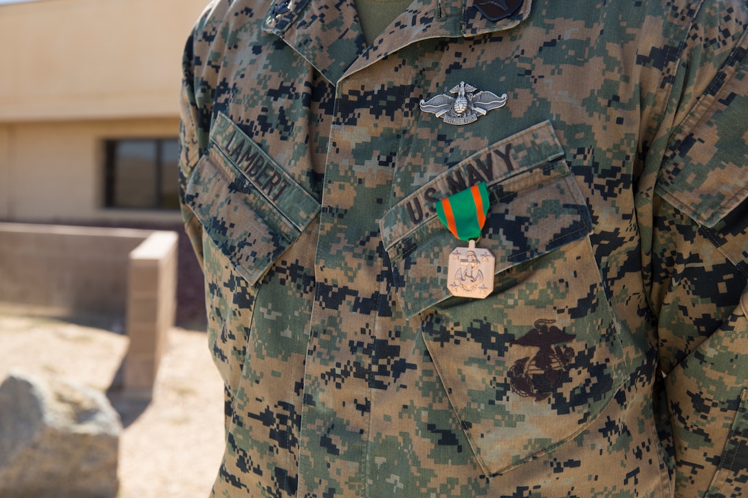 U.S. Navy Hospital Corpsman Third Class Randall Lambert stands with the Navy and Marine Corps Achievement Medal at Cannon Air Defense Complex in Yuma, Ariz Mar 5, 2021. The Navy and Marine Achievement Medal is awarded for superior performance of a service member's duties. ( U.S. Marine Corps photo by Lance Cpl. Matthew Romonoyske-Bean)