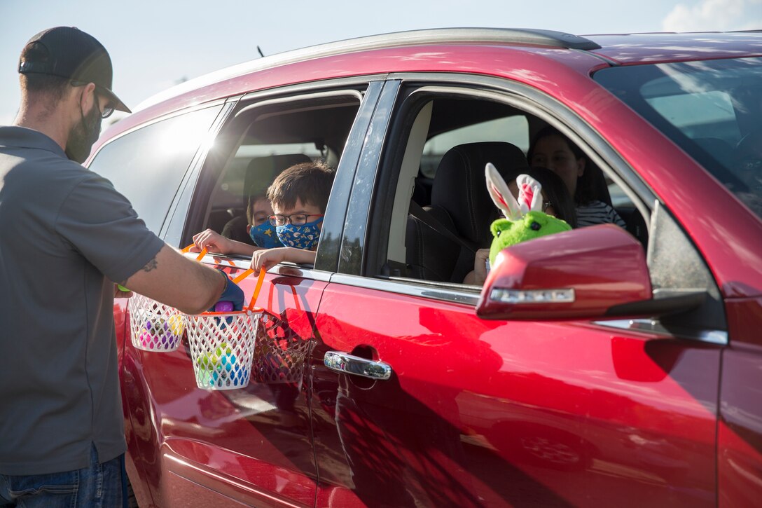 A volunteer hands out eggs during the Easter Eggstravaganza on Marine Corps Air Station Yuma, April 1, 2021. The drive-through event allowed military children and their families a chance to participate in the excitement of gathering eggs, toys and candy. (U.S. Marine Corps photo by Sgt. Nicole Rogge)