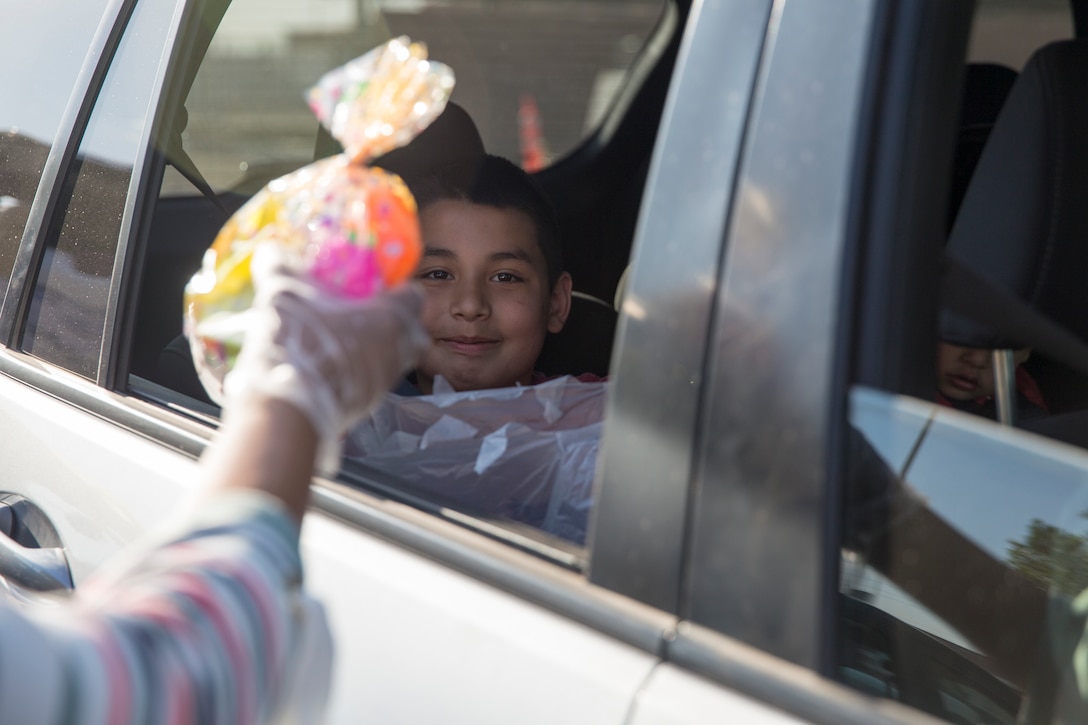 A volunteer hands out eggs during the Easter Eggstravaganza on Marine Corps Air Station Yuma, April 1, 2021. The drive-through event allowed military children and their families a chance to participate in the excitement of gathering eggs, toys and candy. (U.S. Marine Corps photo by Sgt. Nicole Rogge)
