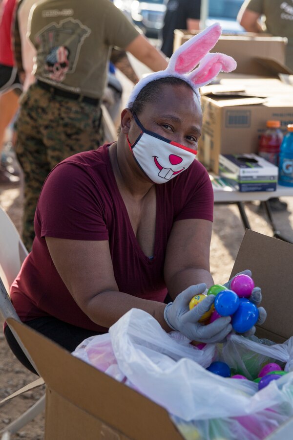 A volunteer gathers eggs to hand out during the Easter Eggstravaganza on Marine Corps Air Station Yuma, April 1, 2021.