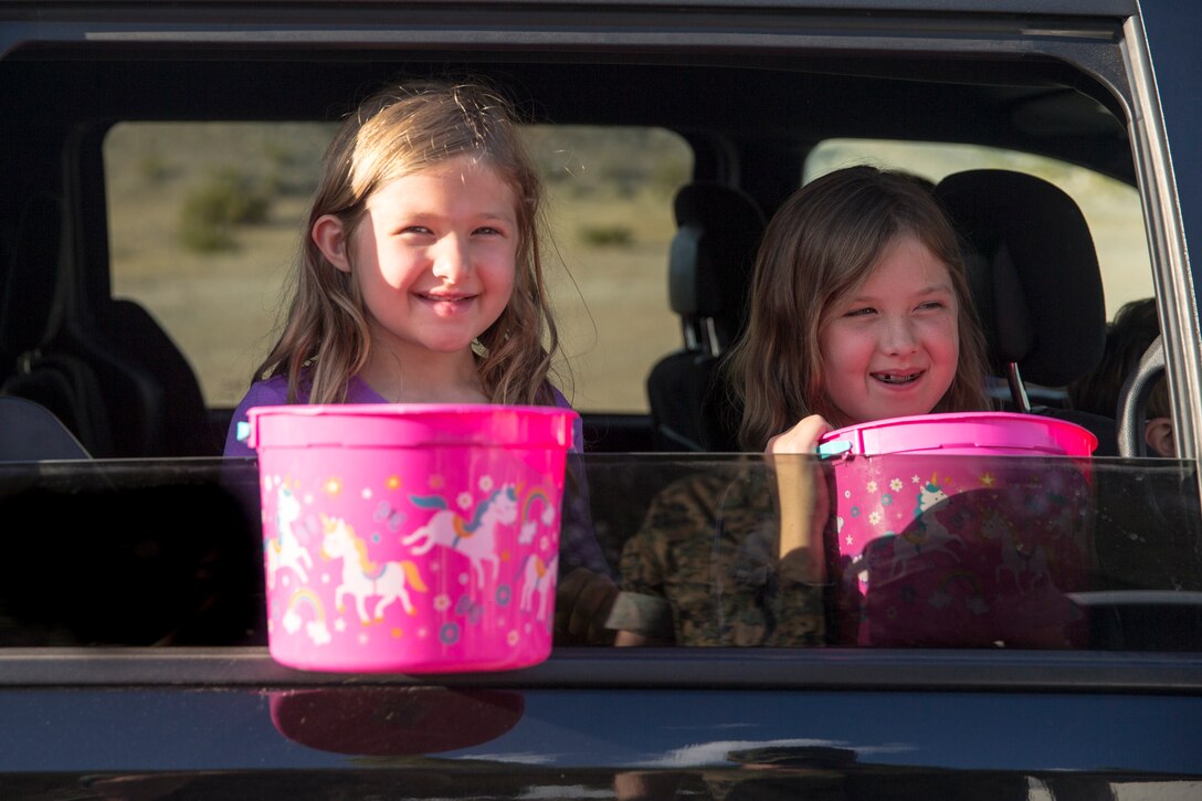 Children hold out their baskets to collect eggs during the Easter Eggstravaganza on Marine Corps Air Station Yuma, April 1, 2021. The drive-through event allowed military children and their families a chance to participate in the excitement of gathering eggs, toys and candy. (U.S. Marine Corps photo by Sgt. Nicole Rogge)