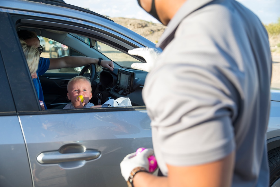 A volunteer hands out eggs during the Easter Eggstravaganza on Marine Corps Air Station Yuma, April 1, 2021. The drive-through event allowed military children and their families a chance to participate in the excitement of gathering eggs, toys and candy. (U.S. Marine Corps photo by Sgt. Nicole Rogge)