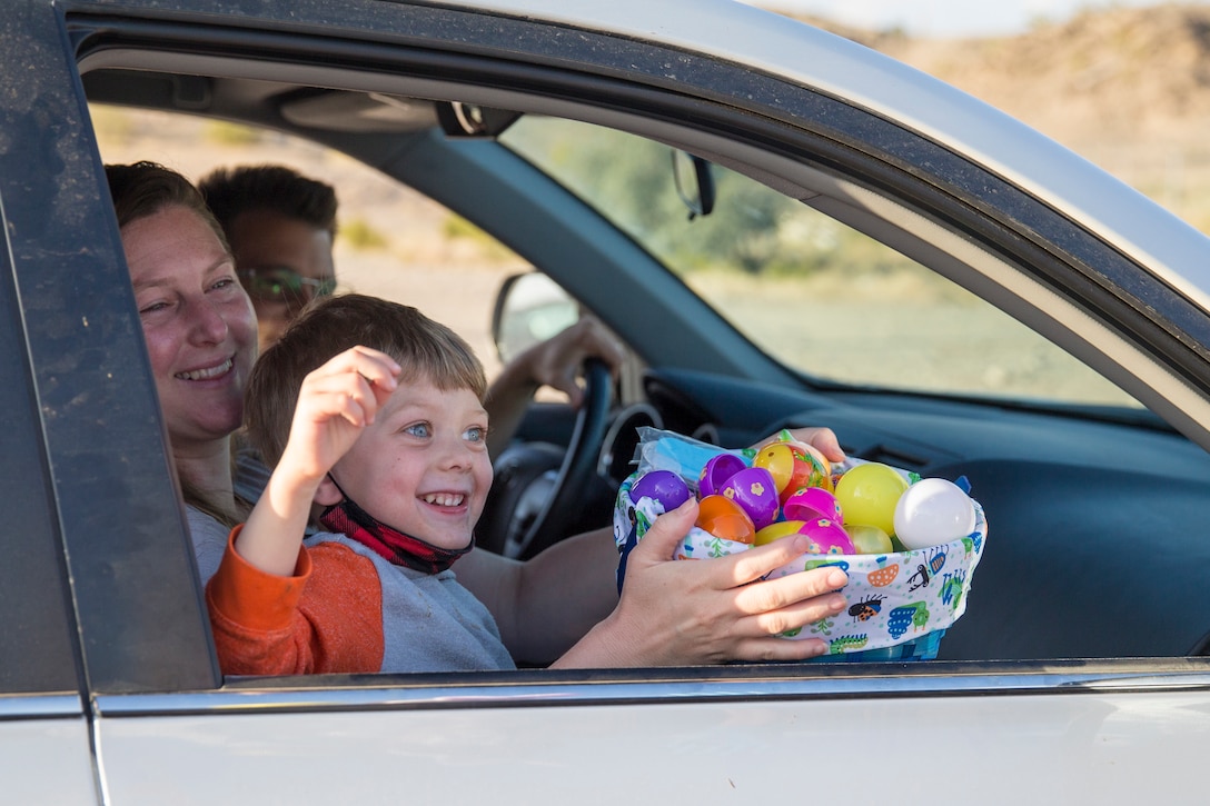 A Child collects eggs during the Easter Eggstravaganza on Marine Corps Air Station Yuma, April 1, 2021. The drive-through event allowed military children and their families a chance to participate in the excitement of gathering eggs, toys and candy. (U.S. Marine Corps photo by Sgt. Nicole Rogge)