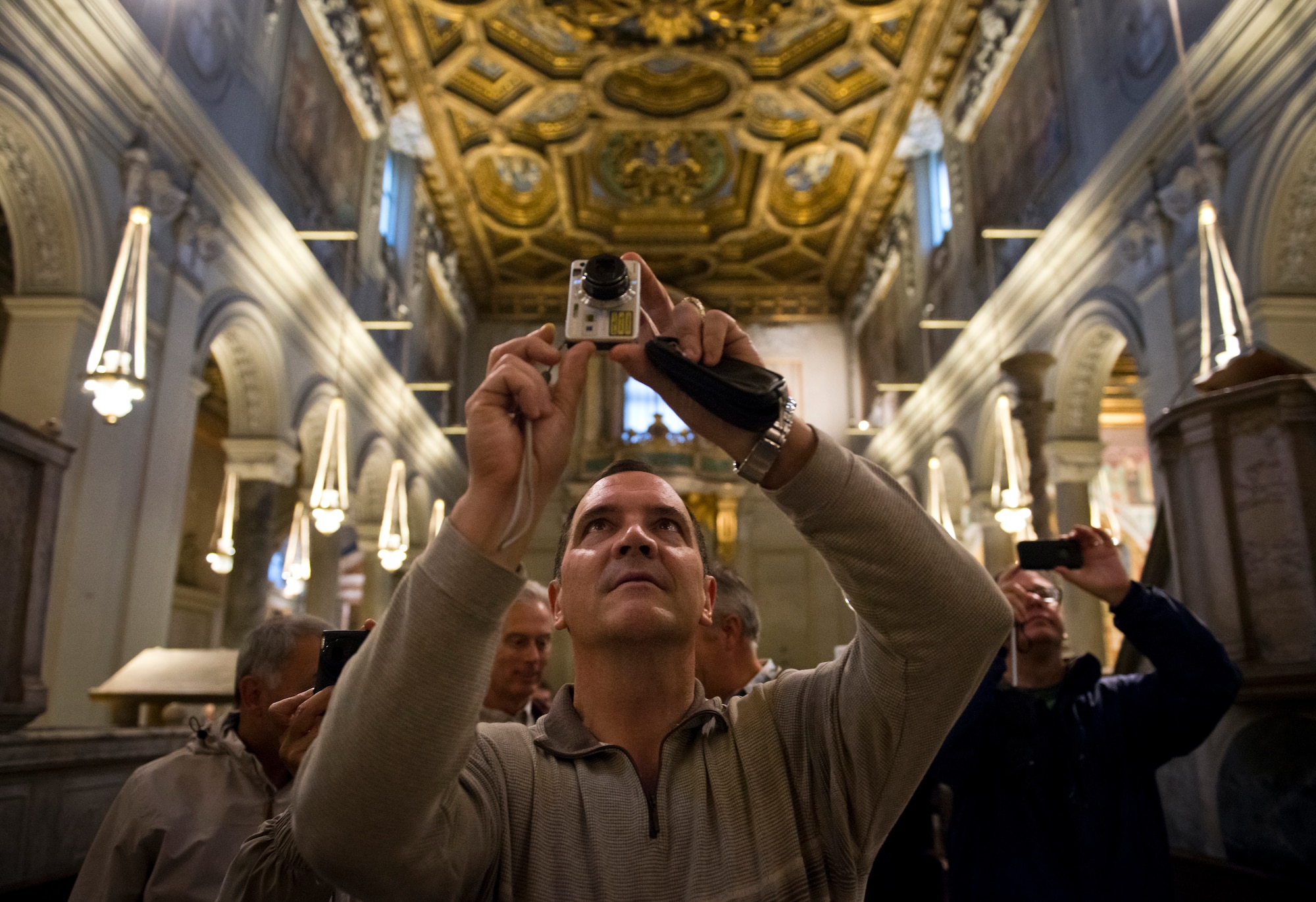 While touring the Basilica of San Clemente, retired Chaplain (Lt. Col.) Stephen Voyt takes a photo of the church's apse. The structure has three levels of history. The present basilica was built in 1100 and beneath is a fourth-century basilica. In the basement is a structure built in the first century. (U.S. Air Force photo/Staff Sgt. Andrew Lee)