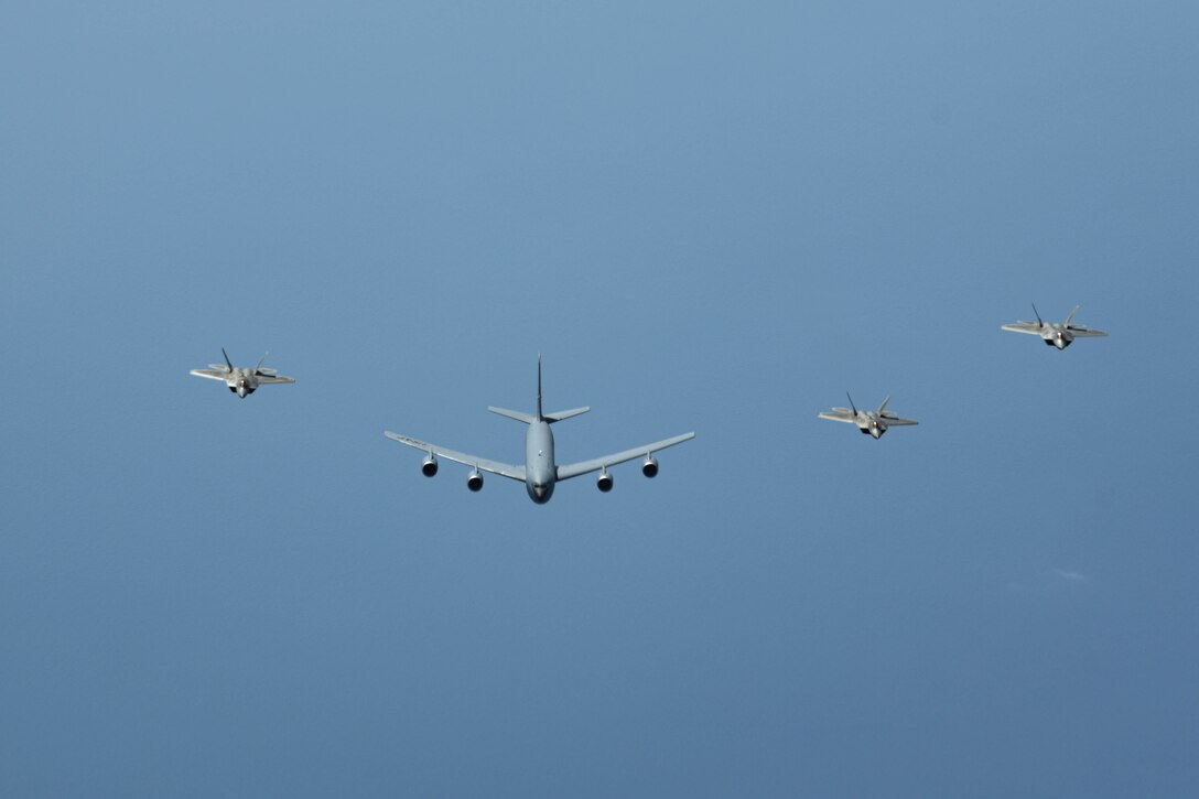 A KC-135 Stratotanker assigned to the 909th Air Refueling Squadron, Kadena Air Base, Japan, flies in formation with U.S. Air Force F-22 Raptor aircraft from the 199th Fighter Squadron, Joint Base Pearl Harbor-Hickam, Hawaii, during a bilateral operation, April 1, 2021. The 199th Fighter Squadron deployed to Marine Corps Air Station Iwakuni, Japan, to conduct integrated training with Marine and Naval forces as part of U.S. Indo-Pacific Command’s dynamic force employment concept. (U.S. Air Force photo by Senior Airman Rebeckah Medeiros)
