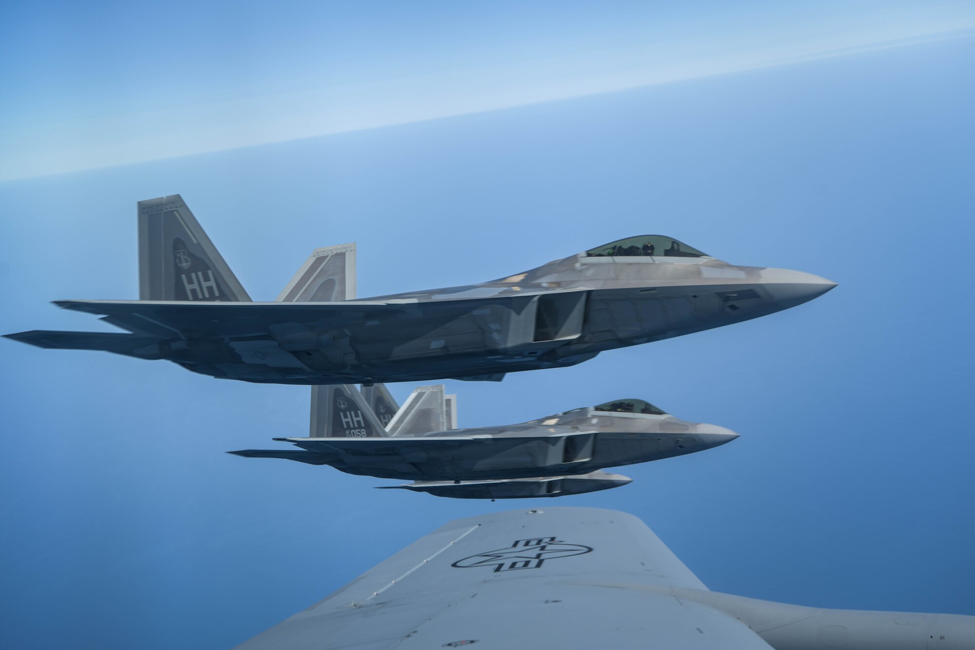 U.S. Air Force Raptors from the 199th Fighter Squadron out of Joint Base Pearl Harbor-Hickam, Hawaii, fly alongside a U.S. Air Force KC-135 Stratotanker from the 909th Air Refueling Squadron during 5th generation fighter training near Japan, April 1, 2021. The F-22 Raptors are currently operating out of Marine Corps Air Station Iwakuni, Japan, to support U.S. Indo-Pacific Command’s dynamic force employment concept. (U.S. Air Force photo by Senior Airman Rebeckah Medeiros)