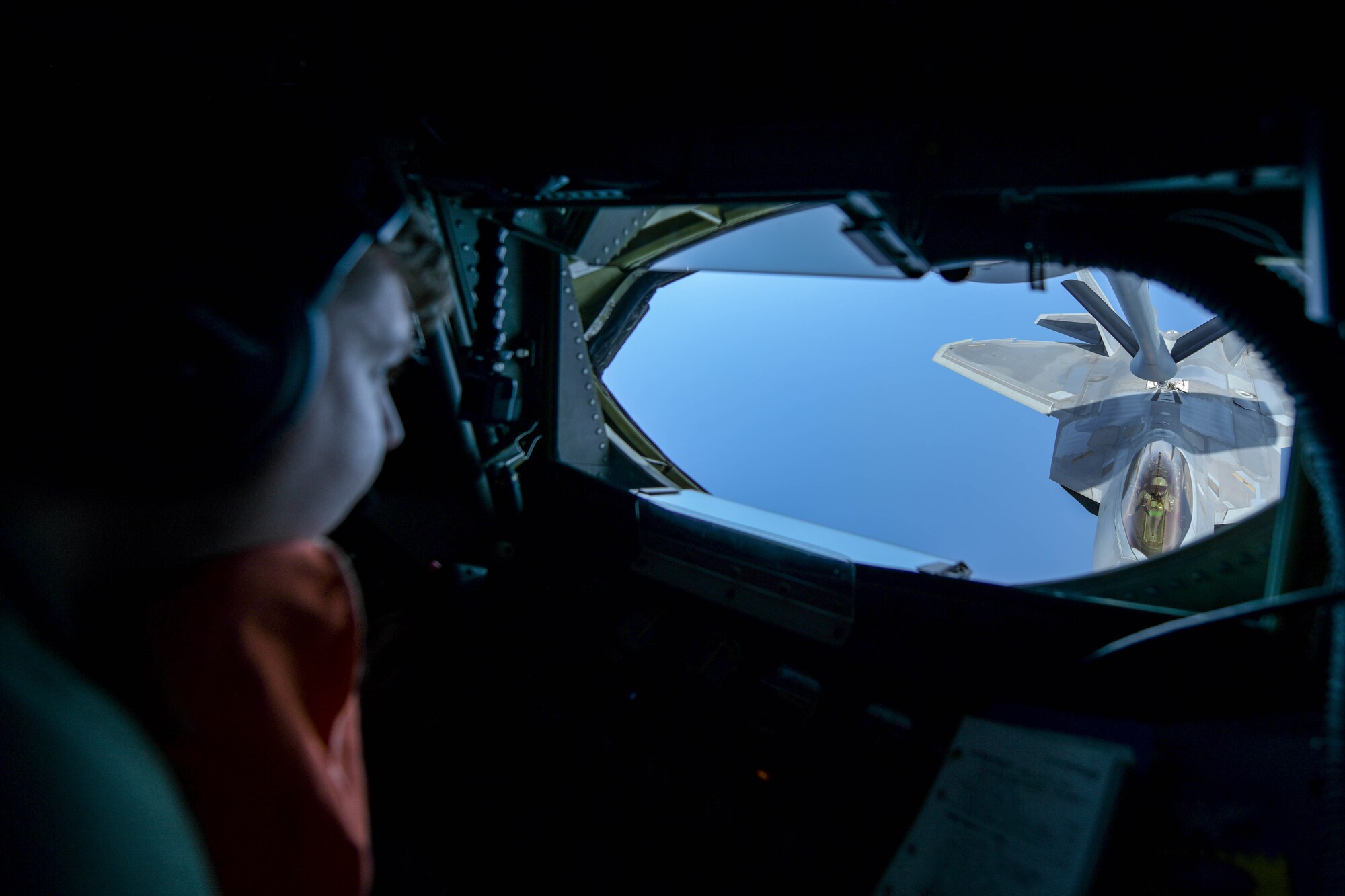 Staff Sgt. Josh Lawson, 909th Air Refueling Squadron a boom operator, refuels a U.S. Air Force F-22 Raptor, from the 199th Fighter Squadron, during a 5th generation fighter operation near Japan, April 1, 2021. The F-22 Raptors are currently operating out of Marine Corps Air Station Iwakuni, Japan, to support U.S. Indo-Pacific Command’s dynamic force employment concept. (U.S. Air Force photo by Senior Airman Rebeckah Medeiros)