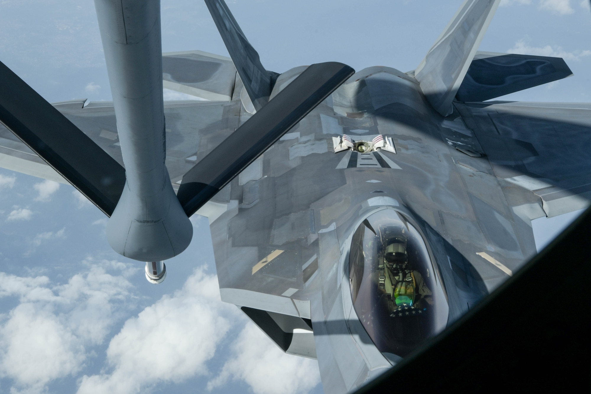 A U.S. Air Force F-22 Raptor, from the 199th Fighter Squadron, is being refueled by a KC-135 Stratotanker, from the 909th Air Refueling Squadron, during a 5th generation fighter operation near Japan, April 1, 2021. The F-22 Raptors are currently operating out of Marine Corps Air Station Iwakuni, Japan, to support U.S. Indo-Pacific Command’s dynamic force employment concept. (U.S. Air Force photo by Senior Airman Rebeckah Medeiros)