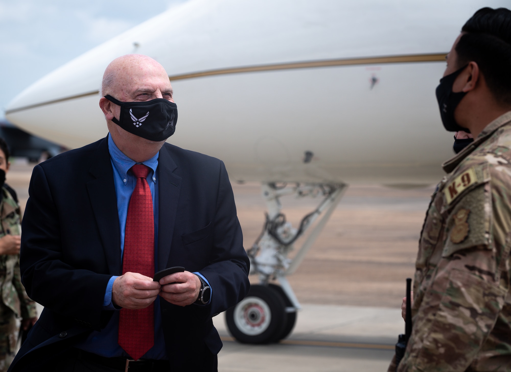 Honorable John P. Roth, acting Secretary of the Air Force, recieves a patch from Staff Sgt. Keola Miller, 2nd Security Force Squadron military working dog handler, during a tour at Barksdale Air Force Base, Louisiana, April 6, 2021.