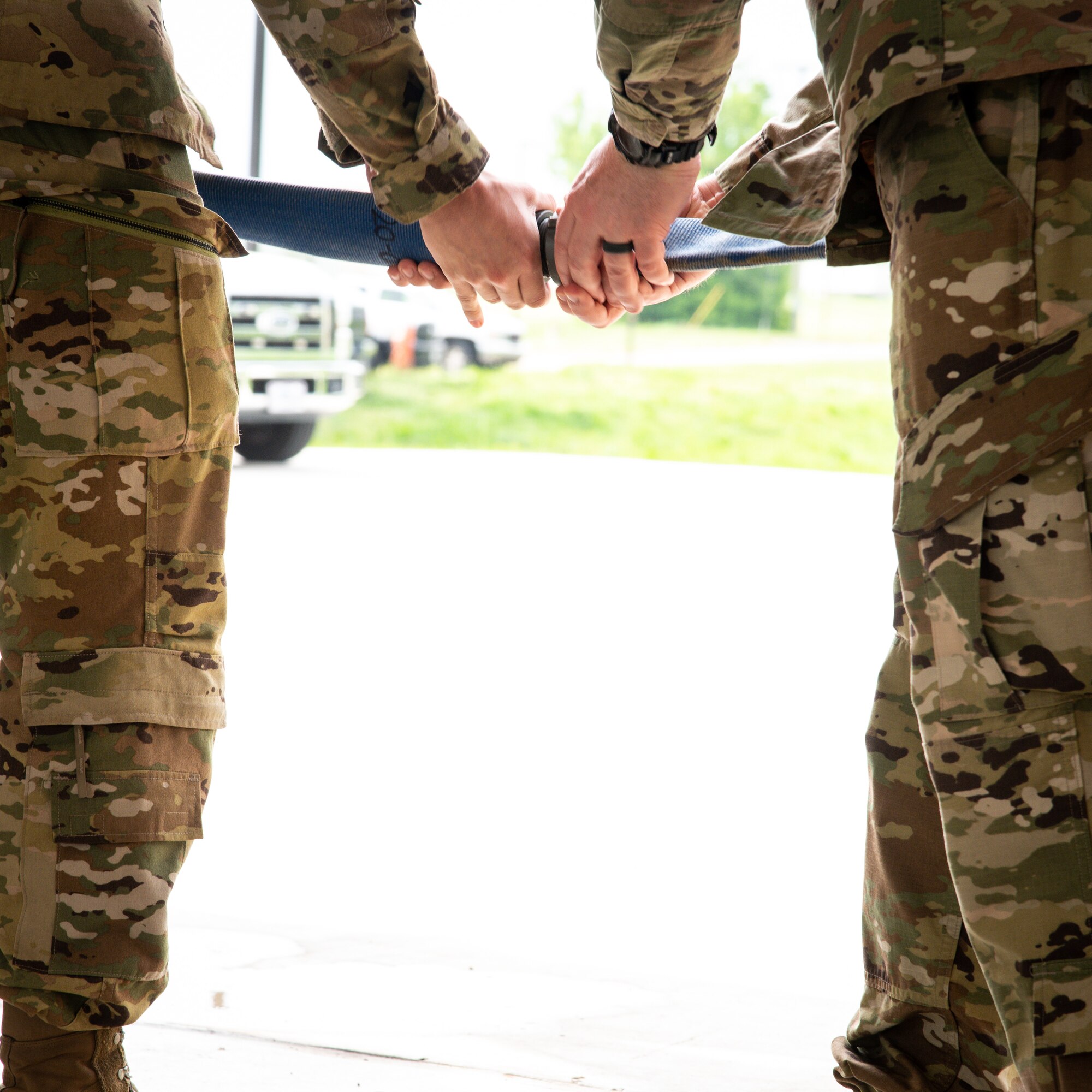 Amn. Maxwell Palmer, 2nd Civil Engineer Squadron, firefighter, and Col. Mark Dmytryszyn, 2nd Bomb Wing commander, detach a connected fire hose symbolizing the cutting of a ribbon for Fire Station Two at Barksdale Air Force Base, Louisiana, April 7, 2021.