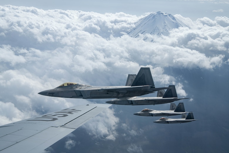 U.S. Air Force Raptors from the 199th Fighter Squadron fly alongside a U.S. Air Force KC-135 Stratotanker from the 909th Air Refueling Squadron during 5th generation fighter training near Mt. Fuji, Japan, April 1, 2021. The F-22 Raptors are currently operating out of Marine Corps Air Station Iwakuni, Japan, to support U.S. Indo-Pacific Command's dynamic force employment concept. (U.S. Air Force photo by Senior Airman Rebeckah Medeiros)