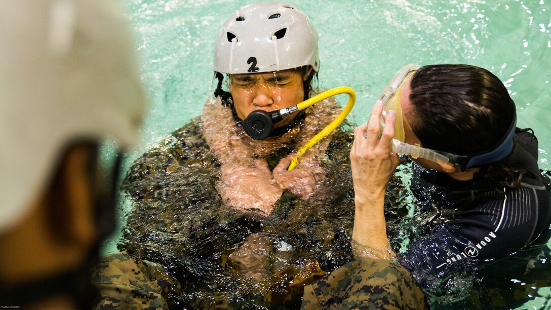 Staff Sgt. Kiriden Benny, the cyber network systems chief with Special Purpose Marine Air-Ground Task Force - Southern Command, practices breathing compressed air during Underwater Egress Training at the Water Survival Training Facility aboard Marine Corps Base Camp Lejeune, North Carolina, March 8, 2017. The purpose of the training is to teach Marines lifesaving skills in the event of an aircraft mishap in the water. (U.S. Marine Corps photo by Cpl. Melissa Martens/ Released)