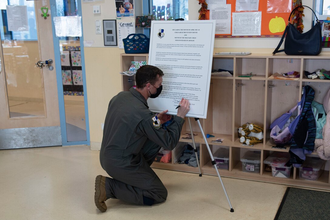 U.S. Air Force Col Epperson, 52nd Fighter Wing commander, signs a proclamation at the Child Development Center on Spangdahlem Air Base, Germany, April 1, 2021. The proclamation showcased the 52nd FW's dedication to military families and taking the necessary steps to prevent child abuse in the community. (U.S. Air Force photo by Senior Airman Melody W. Howley)