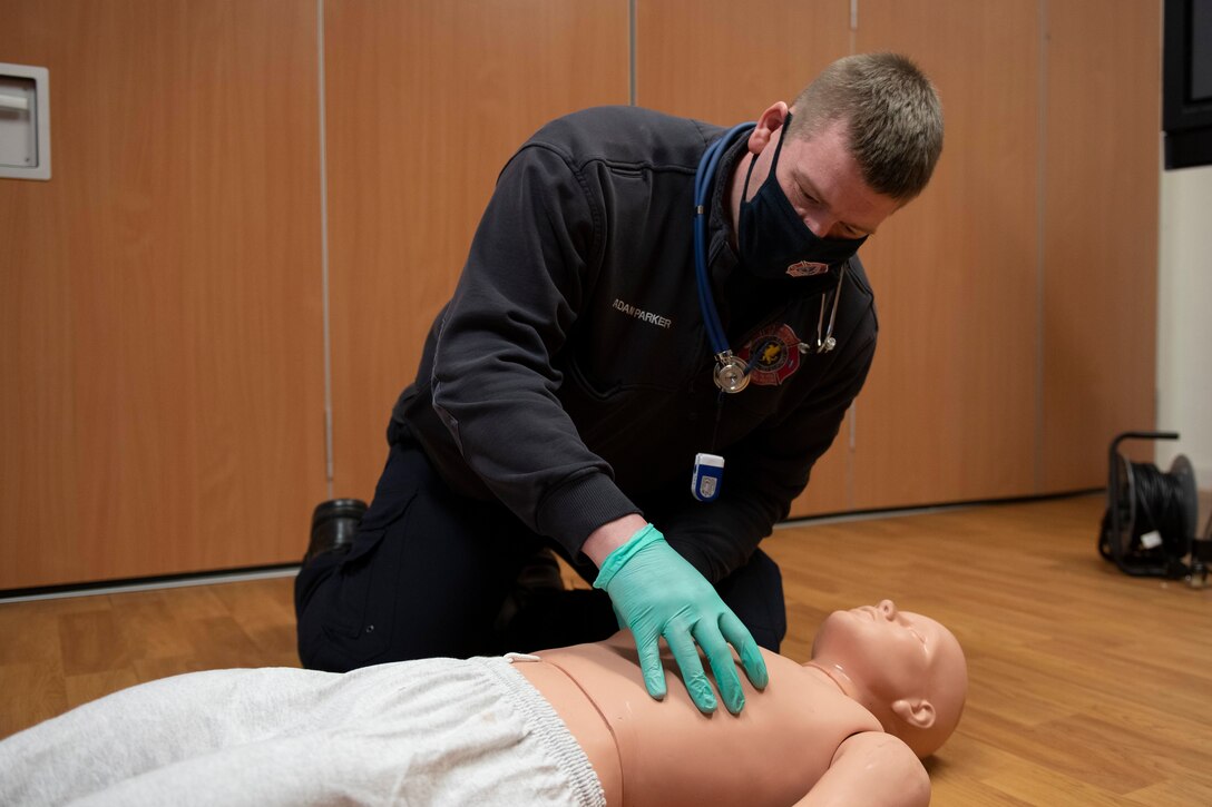Adam Parker, 423rd Civil Engineer Squadron firefighter, assesses a simulated patient's breathing during an EMT practical application exam at Royal Air Force Croughton, England, March 31, 2021. U.K. firefighters across the 501st Combat Support Wing were tested in a practical application of their knowledge and skills, after attending over 280 hours of the U.S. National Registry of Emergency Medical Technicians course. The primary mission of the course was to prepare the fire department to respond to medical emergencies, as EMTs assume the responsibility of operating the ambulances and transporting patients to medical facilities. (U.S. Air Force photo by Senior Airman Jennifer Zima)