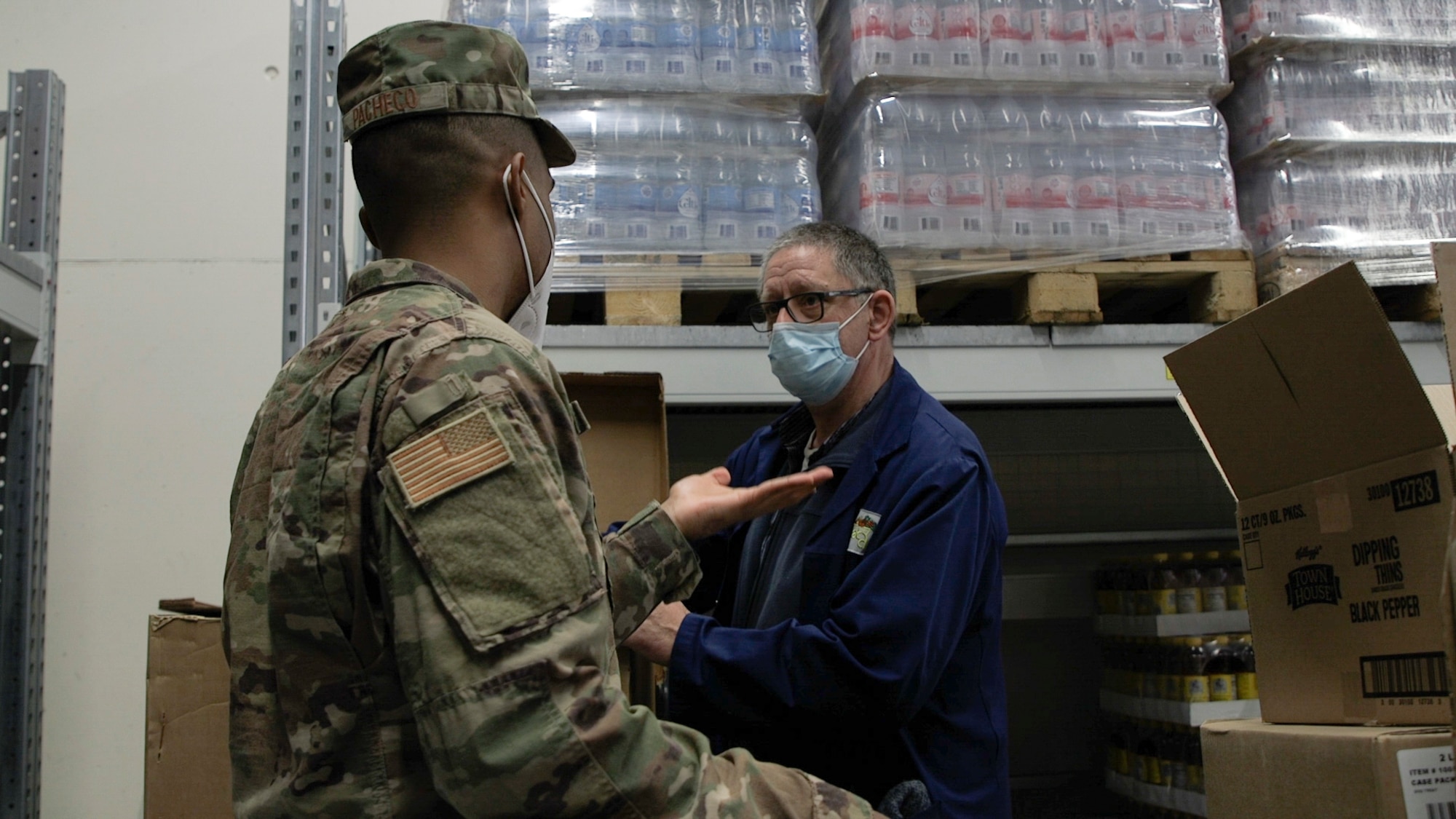 U.S. Air Force Staff Sgt. Nelson Pacheco, 52nd Medical Group Public Health technician (left), talks with a member of the Spangdahlem commissary staff during an inspection at Spangdahlem Air Base Germany, March 29, 2021. The Community Health section of Public Health, includes programs such as food inspections and sexually transmitted infections interviews. (U.S. Air Force photo by Tech. Sgt. Warren D. Spearman Jr.)