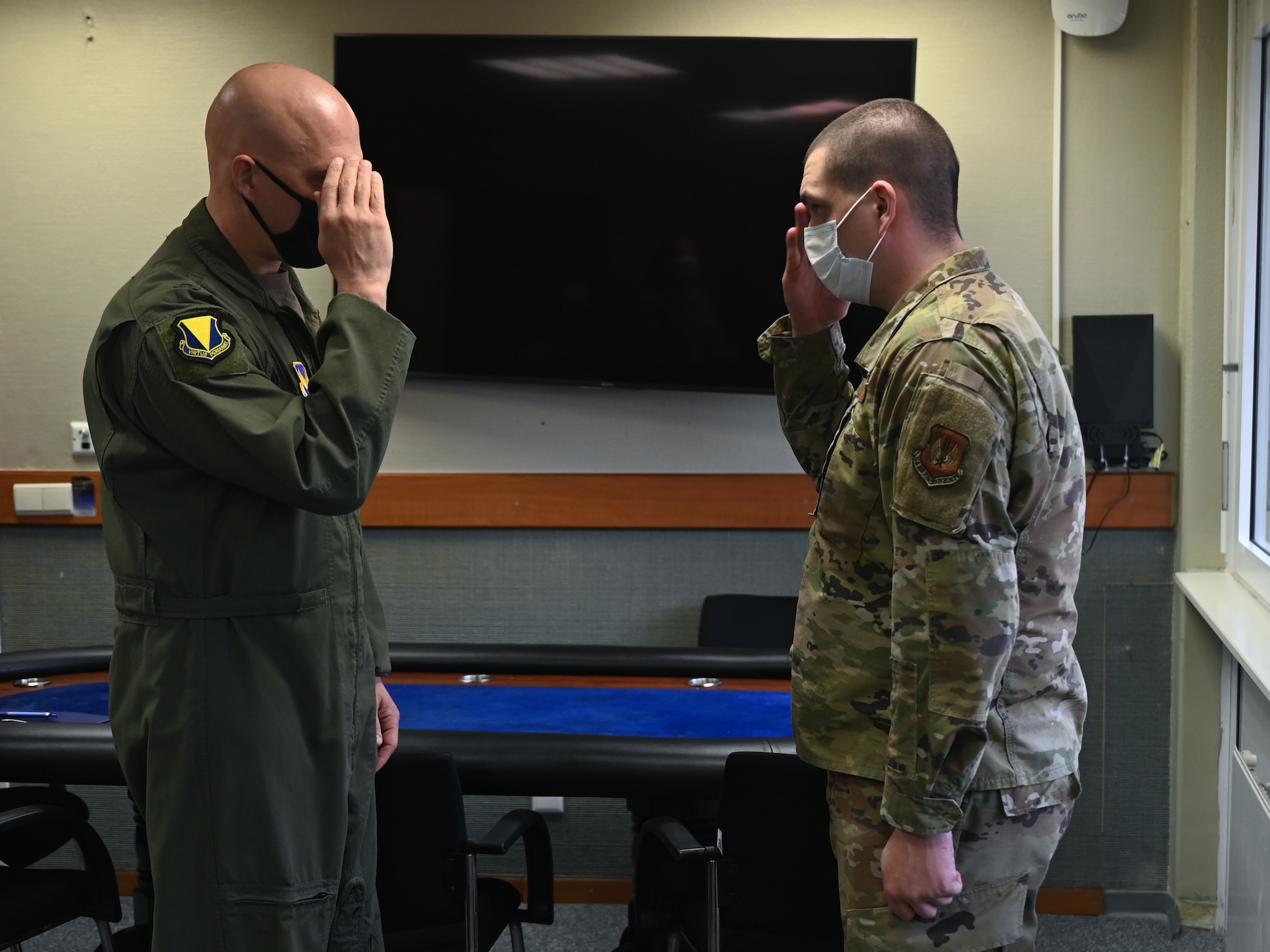 Two men salute each other.