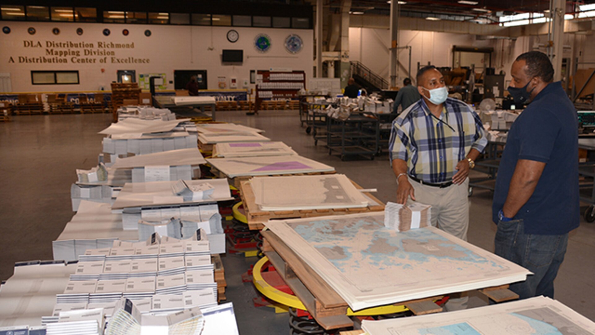 Vincent Price, facilities manager and Eric Harcum, supervisory facilities specialist, both from Defense Logistics Agency Distribution, discuss mailing updated map products.