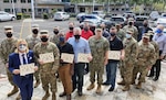 A group of people pose with end of exercise certificates.