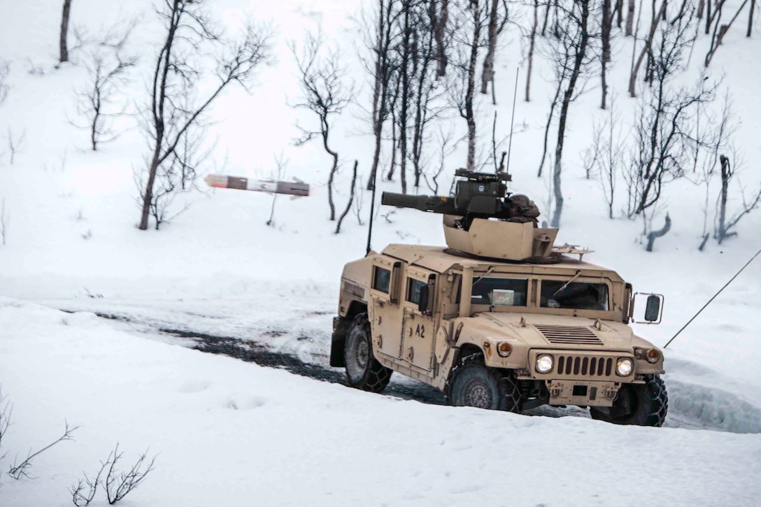 A military vehicle fires a missile in a snowy terrain.