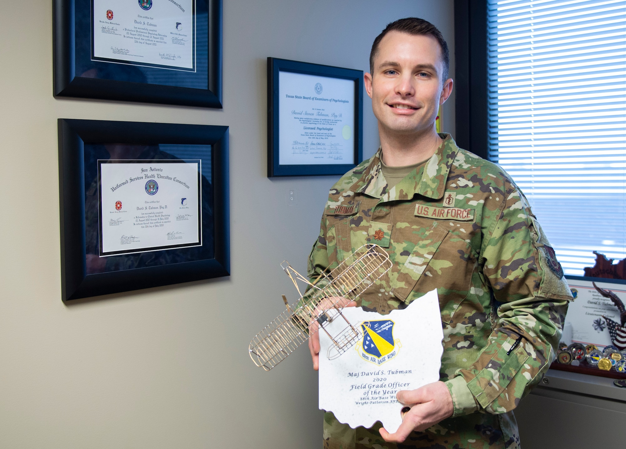 Maj. David Tubman stands in his office with the 88th Air Base Wing’s 2020 Field Grade Officer of the Year Award for his work in the 88th Medical Group’s Mental Health Clinic. U.S. Air Force photo/Wesley Farnsworth