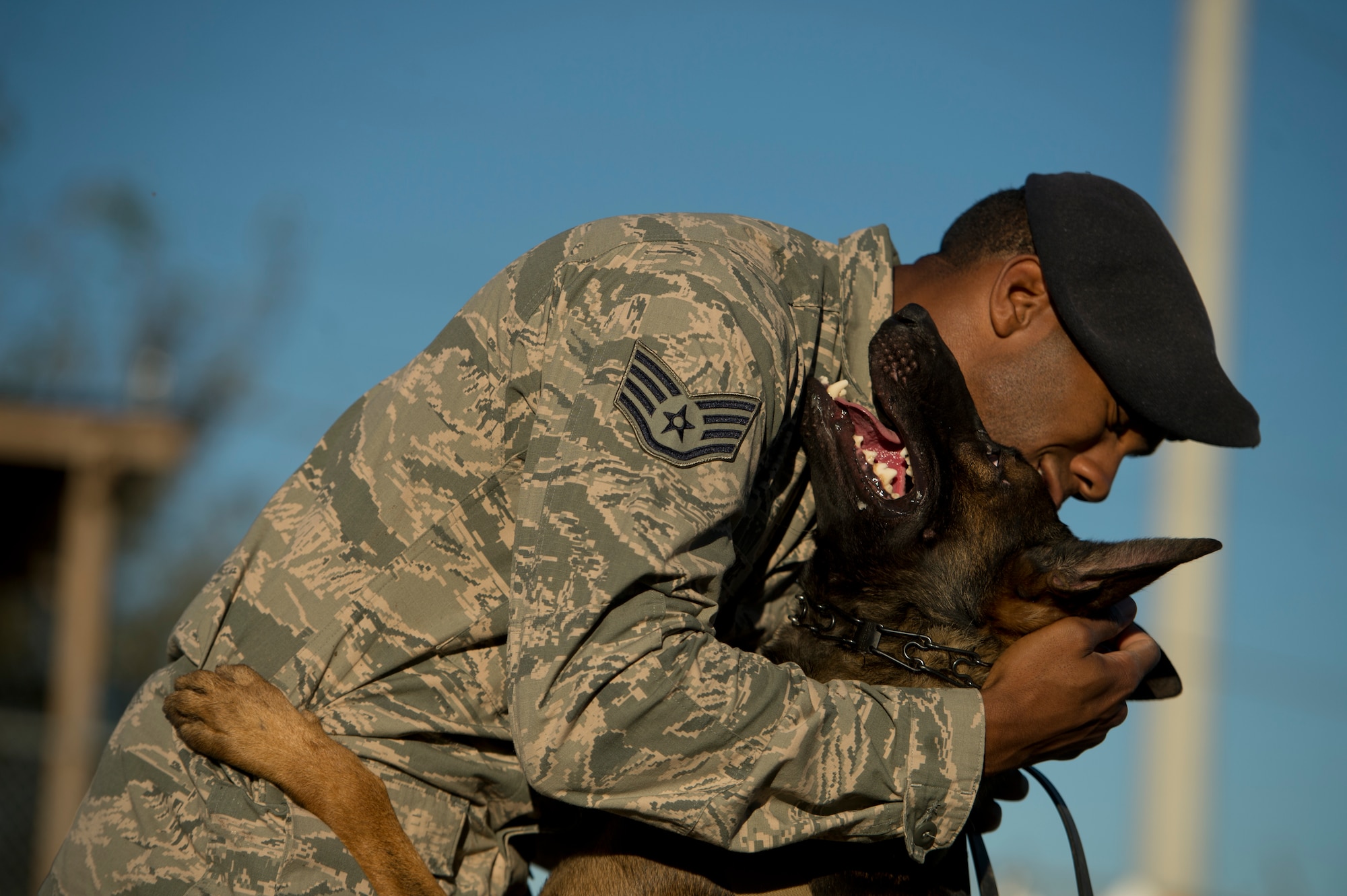 Staff Sgt. Sharif DeLarge, a military working dog handler from the 802nd Security Forces Squadron, hugs his military working dog OOlaf after a controlled aggression exercise at Joint Base San Antonio-Lackland. DeLarge and military working dog handlers assigned to JBSA-Lackland fulfill daily law enforcement requirements or train to remain mission-ready. (U.S. Air force photo/Staff Sgt. Vernon Young Jr.)