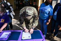 Col. Mark Dmytryszyn, 2nd Bomb Wing commander, signs two proclamations affirming Barksdale’s commitment to preventing child abuse during the Military Child Parade at Barksdale Air Force Base, Louisiana, April 1, 2021.