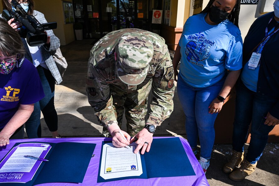 Col. Mark Dmytryszyn, 2nd Bomb Wing commander, signs two proclamations affirming Barksdale’s commitment to preventing child abuse during the Military Child Parade at Barksdale Air Force Base, Louisiana, April 1, 2021.