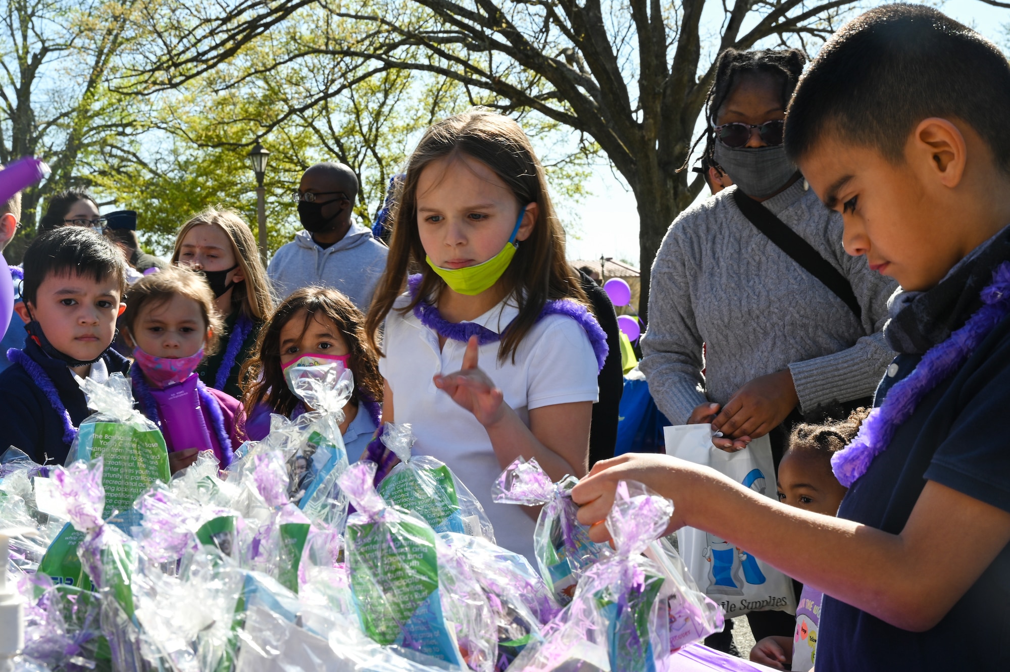 Military children grab gift bags during the Military Child Parade at Barksdale Air Force Base, Louisiana, April 1, 2021.
