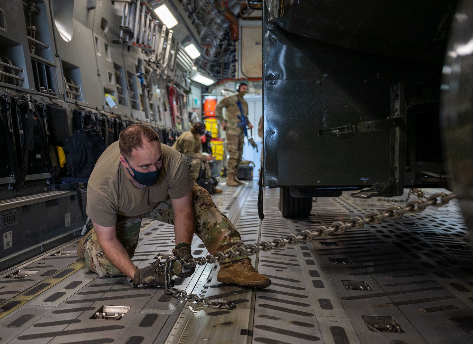 Senior Airman Eric Jones, 3rd Airlift Squadron loadmaster, chains a fuel truck to the cargo floor of a Dover Air Force Base C-17 Globemaster III during exercise Razor Talon at Seymour Johnson AFB, North Carolina, March 23, 2021. Team Dover’s Multi-Capable Airmen program developed and equipped seven Airmen to perform tasks outside of their Air Force Specialty Codes. RT was the first time an MCA team from Dover AFB participated in an exercise. (U.S. Air Force photo by Airman 1st Class Faith Schaefer)