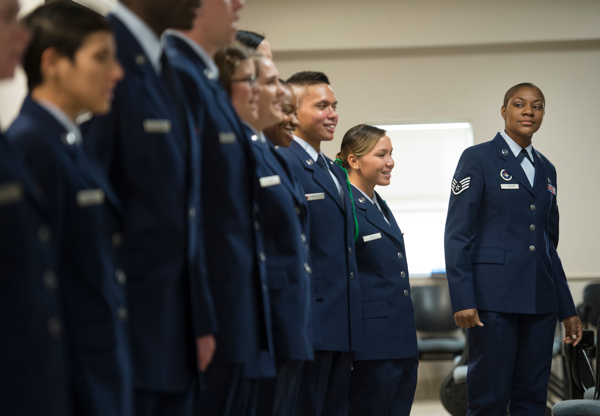 Staff Sgt. Chantel Thibeaux, Joint Base-Fort Sam Houston, Texas, dental assistant instructor, peeks down at a line of Airmen laughing during their graduation rehearsal. Thibeaux's battle with breast cancer didn't stop her from bonding with the Airmen she was charged to prepare for the operational Air Force. (U.S. Air Force photo/Staff Sgt. Vernon Young Jr.)