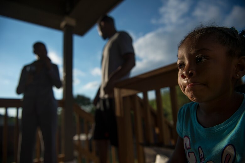 Somaya, 2, daughter of Staff Sgt. Chantel Thibeaux, Joint Base-Fort Sam Houston, Texas, dental assistant instructor, looks into the house while her mother and father Wendell talk during a family barbeque.  At two years old, Somaya is unaware of her mothers battle with cancer and tried to play with her every chance she can, but is limited to certain activities. About 15 family and friends gathered at her house to celebrate a successful surgery and provide love to Thibeaux during her quest to defeat cancer. (U.S. Air Force photo/Staff Sgt. Vernon Young Jr.)