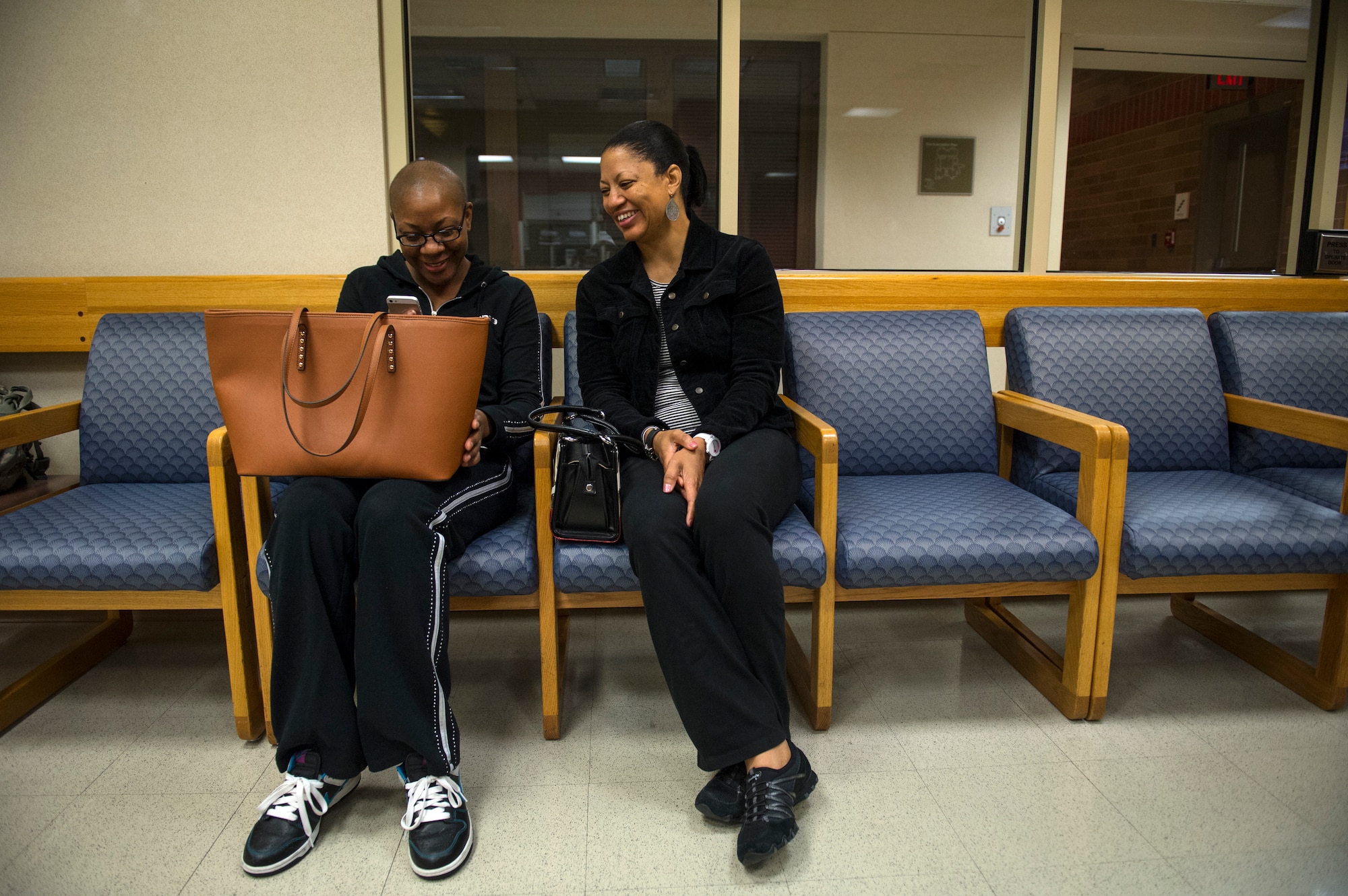 Staff Sgt. Chantel Thibeaux, Joint Base-Fort Sam Houston, Texas, dental assistant instructor, shares a laugh with her mother Carla while watching a video on her phone. As Thibeaux and her mother waited for doctors to perform checks prior to double mastectomy surgery, Carla kept her daughter in good spirits with laughs and loving reminders. (U.S. Air Force photo/Staff Sgt. Vernon Young Jr.)