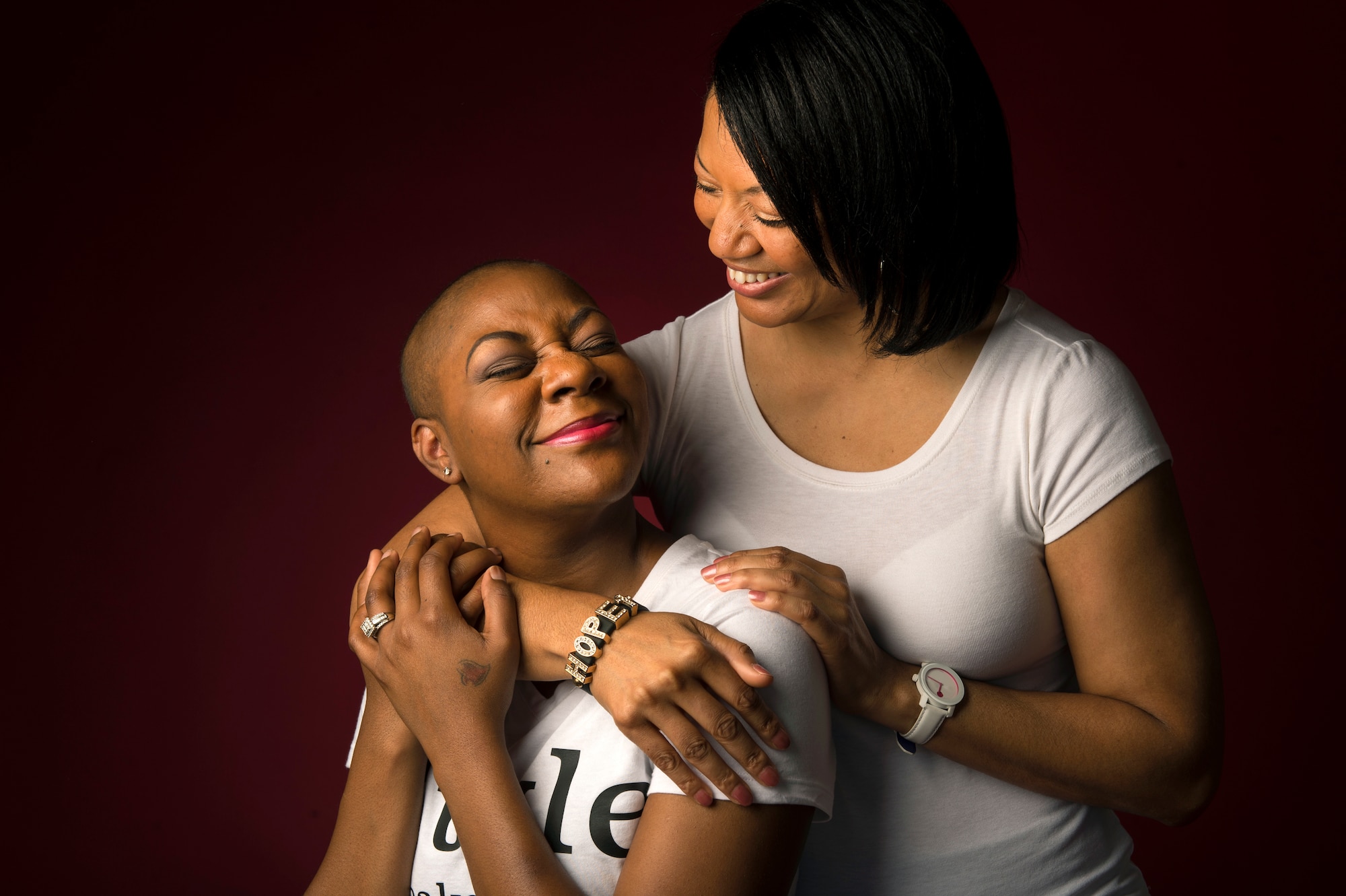 Staff Sgt. Chantel Thibeaux, Joint Base-Fort Sam Houston, Texas, dental assistant instructor, smiles as her mother Carla gives her a hug. Thibeaux, 27, the youngest breast cancer patient at San Antonio Medical Center, was diagnosed with breast cancer in February 2014. Her mother Carla scheduled administrative leave to be there for Thibeaux and her family during double mastectomy surgery. (U.S. Air Force photo/Staff Sgt. Vernon Young Jr.)