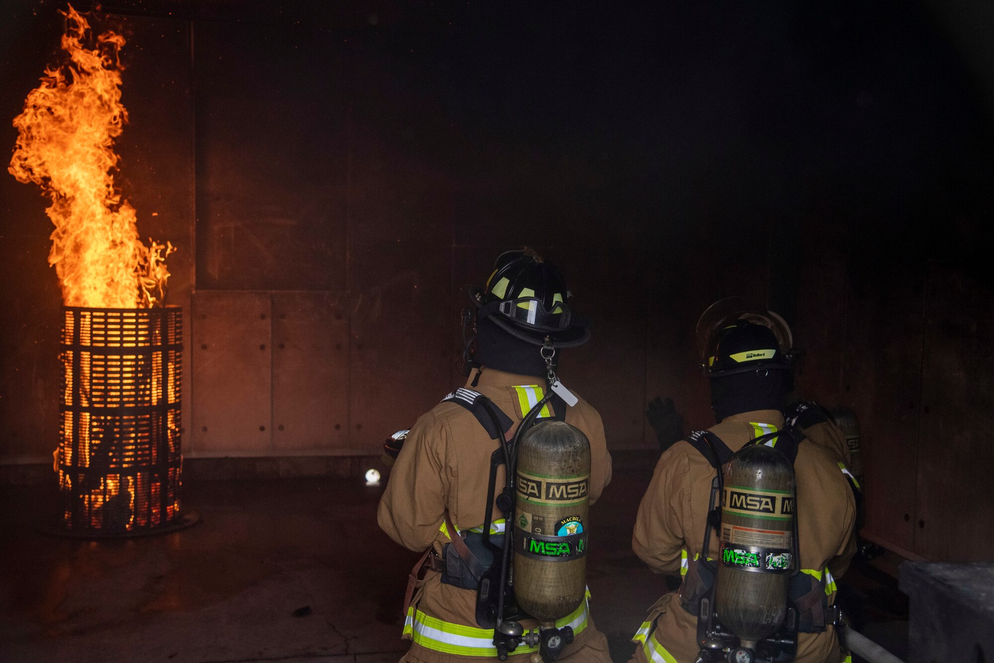 6th Civil Engineer Squadron (CES) Fire and Emergency Services Airmen examine a fire during a live-burn exercise at MacDill Air Force Base, Fla, March 23, 2021.