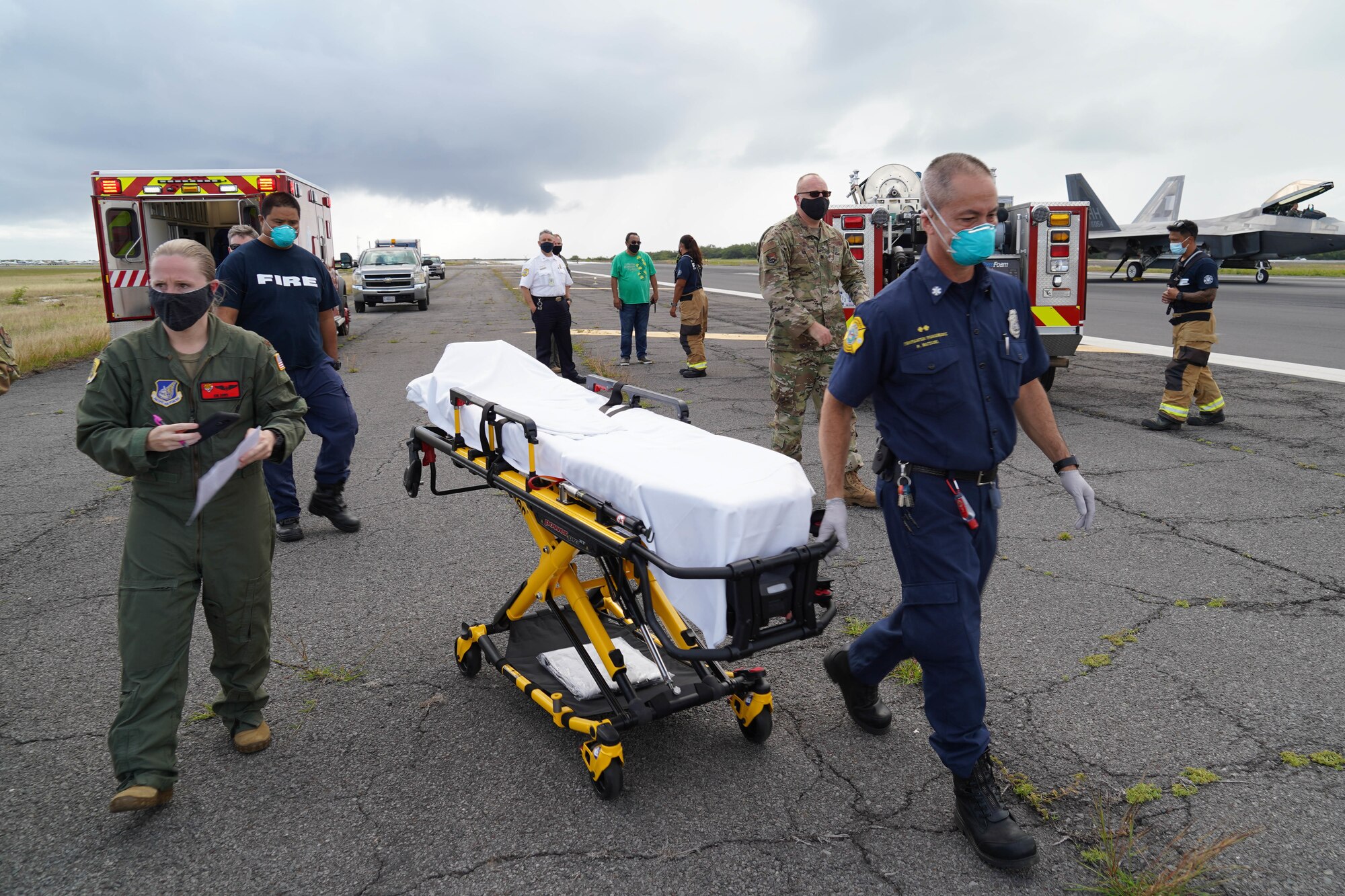 Paramedics and firefighters from the Joint Base Pearl Harbor-Hickam Federal Fire Department and 15th Medical Group respond to a simulated in-flight emergency at JBPHH, Hawaii, March 23, 2021. The exercise allowed emergency responders to respond to an aircrew member experiencing decompression sickness while in flight. (U.S. Air Force photo by Senior Airman Jermaine Ayers)