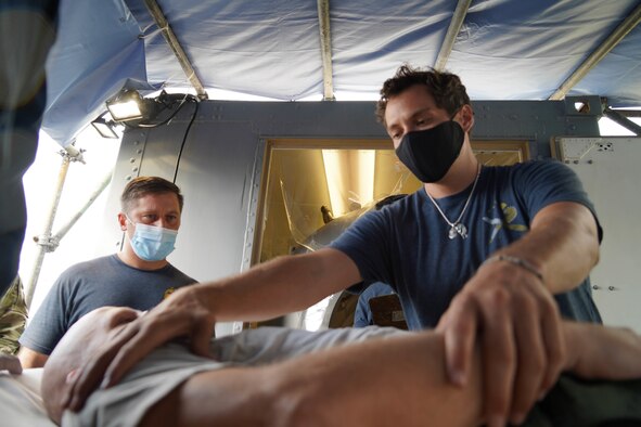 Paramedics and firefighters from the Joint Base Pearl Harbor-Hickam Federal Fire Department and 15th Medical Group respond to a simulated in-flight emergency at JBPHH, Hawaii, March 23, 2021. The exercise allowed emergency responders to respond to an aircrew member experiencing decompression sickness while in flight. (U.S. Air Force photo by Senior Airman Jermaine Ayers)
