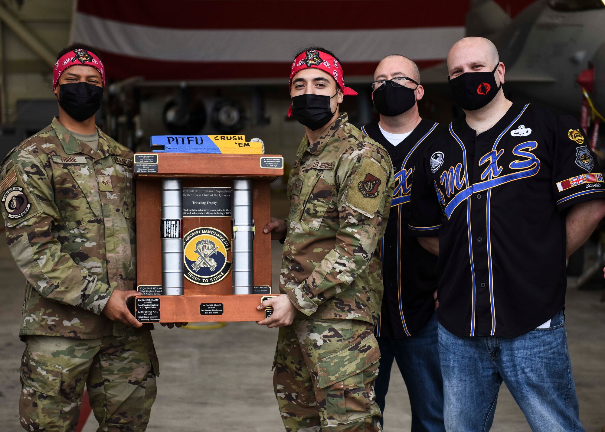 Airmen pose with a trophy