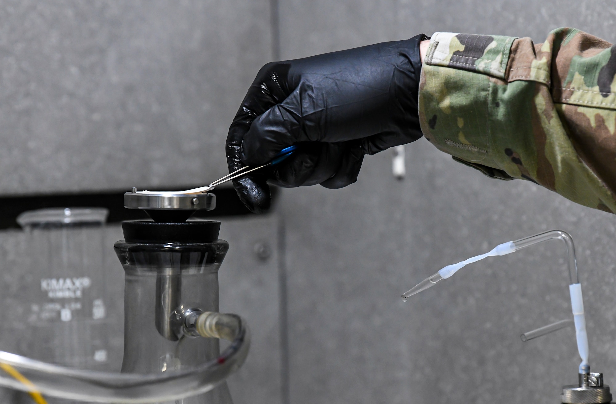 Staff Sgt. Brian Elrod, 436th Logistics Readiness Squadron fuels laboratory noncommissioned officer in charge, removes a micron filter during the bottle method testing process at Dover Air Force Base, Delaware, Jan. 12, 2021. The micron filter is weighed before the bottle test, and a gallon of fuel is then poured through the filter to collect particulates. The filter is then dried and weighed again. The weight difference determines how much particulate is in a given sample of fuel. (U.S. Air Force photo by Airman 1st Class Stephani Barge)