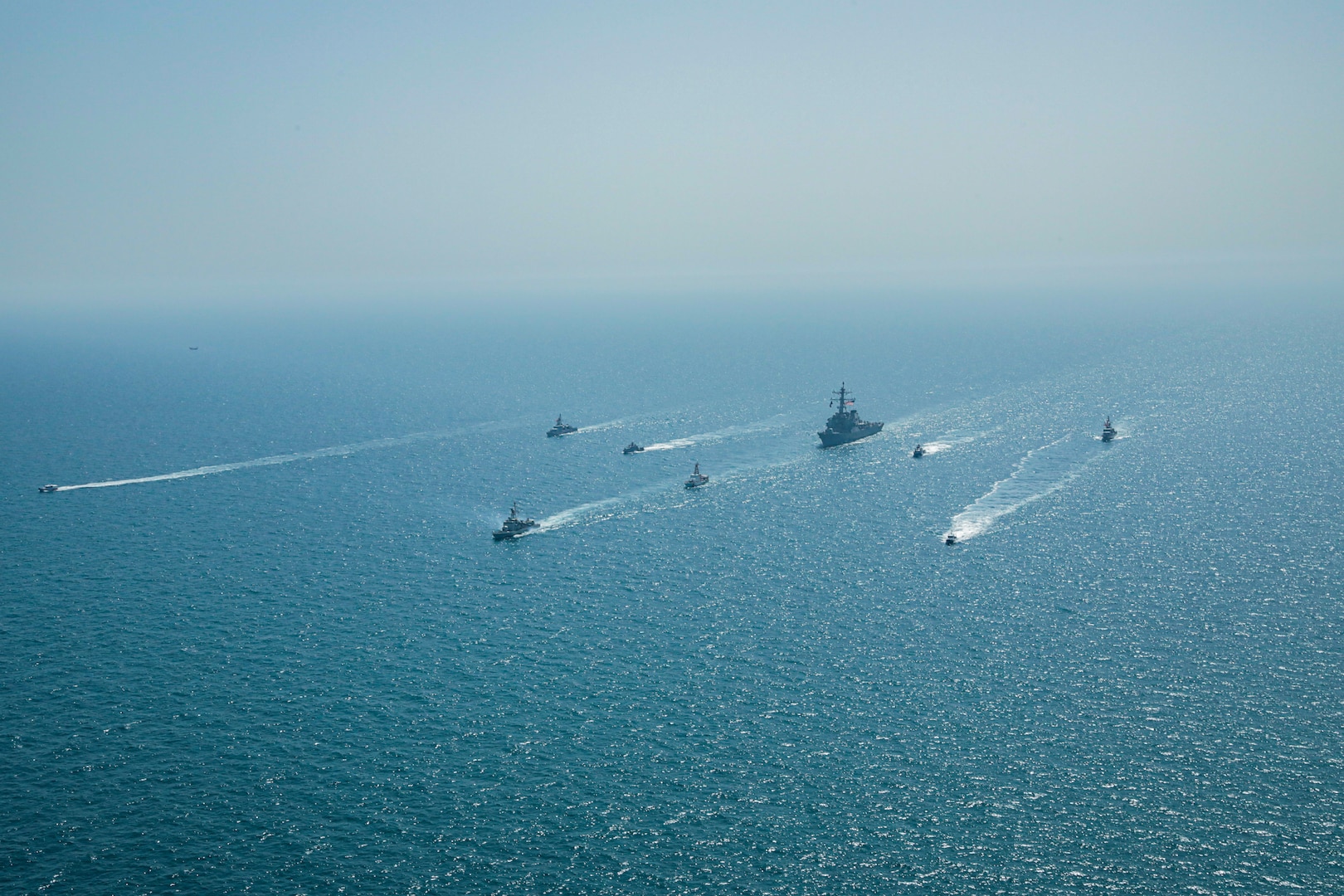 Royal Bahrain Naval Force fast attack craft RBNS Abdul Rahman Al-fadel (P 22), Bahrain Coast Guard response boats Hawar 5 and Hawar 4, U.S. Navy guided-missile destroyer USS Mahan (DDG 72), patrol coastal ships USS Squall (PC 7) and USS Hurricane (PC 3), U.S. Coast Guard patrol boat USCGC Adak (WBP 1333) and two Mark VI patrol boats operate in formation during exercise Neon Defender in the Arabian Gulf, April 7. Neon Defender 21 is a bilateral maritime exercise between the U.S. and Bahrain, designed to enhance interoperability and readiness, fortify military-to-military relationships and advance operational capabilities, allowing participating naval forces to effectively develop the necessary skills to address threats to regional security, freedom of navigation and the free flow of commerce. (Army Photo by Spc. Evens Milcette Jr.)