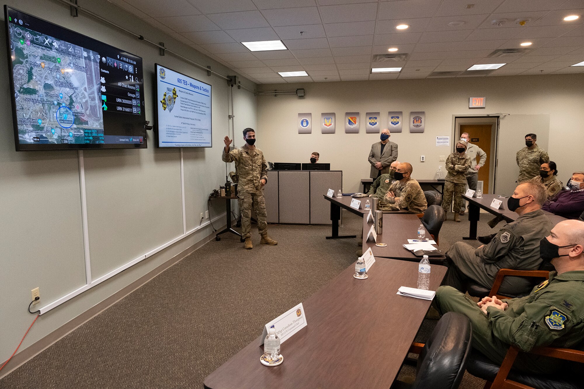 Photo of Airman briefing group of individual seated at tables