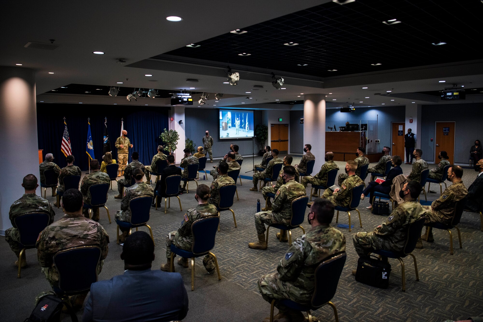 Attendees of an all call led by U.S. Space Force Gen. John W. “Jay” Raymond, Chief of Space Operations, and Chief Master Sergeant of the Space Force Roger A. Towberman, listen in as Raymond speaks in the Gordon Conference Center at Los Angeles Air Force Base, California, April 8, 2021. In-person and virtual attendees were briefed on topics including diversity and inclusion, integrating the Space Force, and the planned organizational structure of the Space Systems Command scheduled to activate this summer.  (U.S. Space Force photo by Staff Sgt. Luke Kitterman)