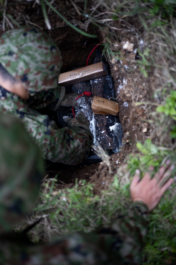 Japan Ground Self-Defense Force (JGSDF) Sgt. Takashi Kawahara, an explosive ordnance disposal (EOD) technician with 101st Explosive Ordnance Disposal Unit, prepares C4 for placement on unexploded ordnance (UXO) on Ie Shima Training Facility (ISTF), Okinawa, Japan, April 6, 2021. Over the past five years, ordnance has been collected on Iejima and stored away. At the request of the Ie Village office mayor, the JGSDF and Marine Corps Installations Pacific EOD technicians conducted UXO disposal operations to destroy the collected ordnance. ISTF is the only active demolition range aboard Iejima where the operation can be conducted. Kawahara is a native of Nagano Prefecture. (U.S. Marine Corps photo by Cpl. Terry Wong)