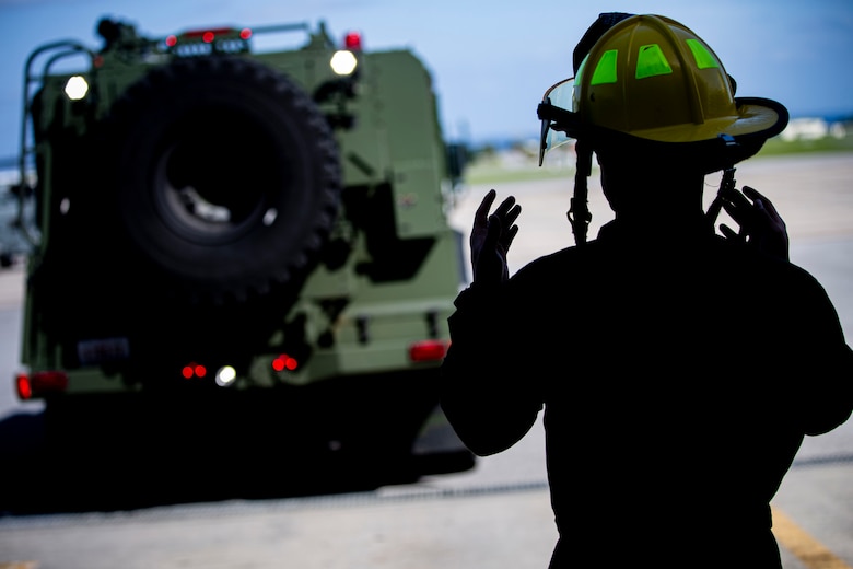U.S. Marine Corps Pfc. Elijah Stewart, an expeditionary firefighting and rescue (EFR) specialist with Headquarters and Headquarters Squadron (H&HS), Marine Corps Installations Pacific, guides an Oshkosh P-19R Aircraft Rescue and Firefighting Vehicle after a turret drill on Marine Corps Air Station Futenma, Okinawa, Japan, April 7, 2021.  EFR specialist Marines with H&HS provide aircraft rescue and firefighting services in support of airfield operations and respond to any fire-related emergencies and situations with a maximum response time of five minutes. Stewart is a native of Independence, Missouri. (U.S. Marine Corps photo by Lance Cpl. Alex Fairchild)